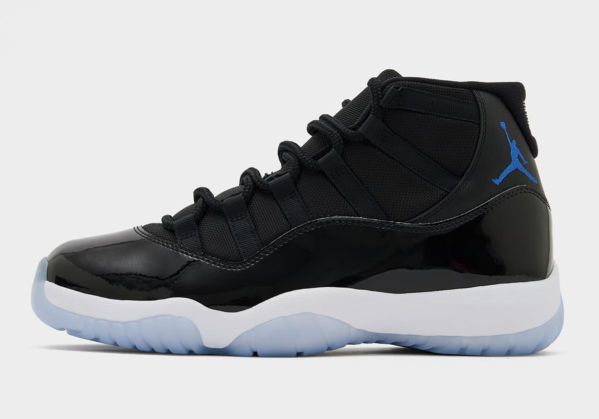 Air Jordan 11 Space Jam 2026 de perfil con charol negro, Jumpman Varsity Royal y suela translúcida